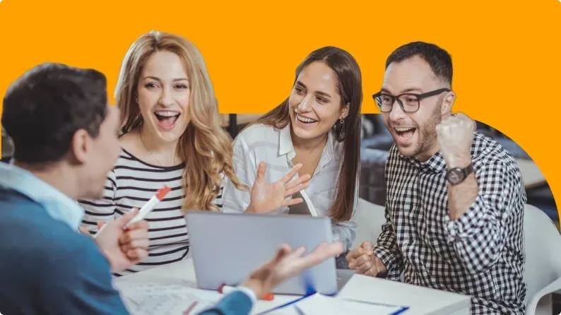 Four coworkers engaged in a lively discussion around a laptop, demonstrating teamwork and communication skills.